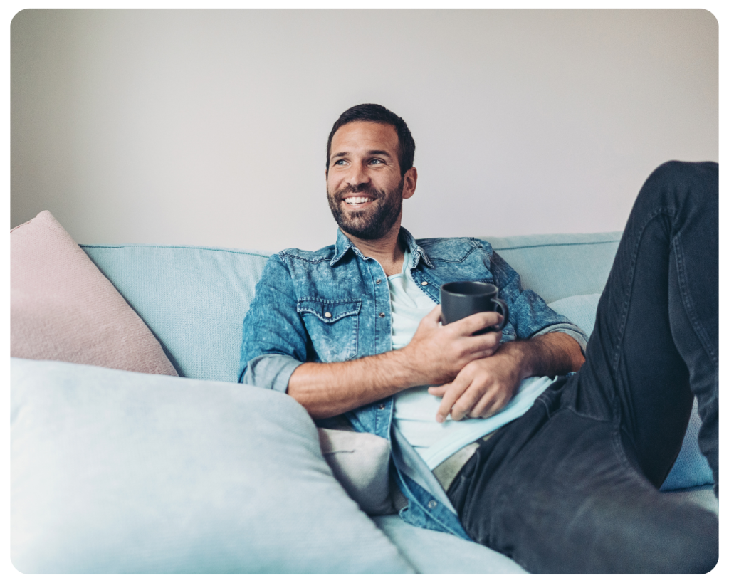 MMHC Psychiatry man relaxing on couch with coffee